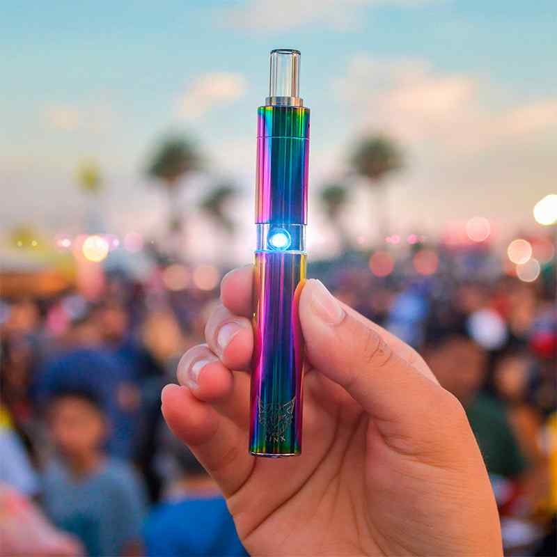 Linx-Hypnos Zero Concentrate Vaporizer Iridescent Rainbow held by hand outdoors in front of blurred crowd